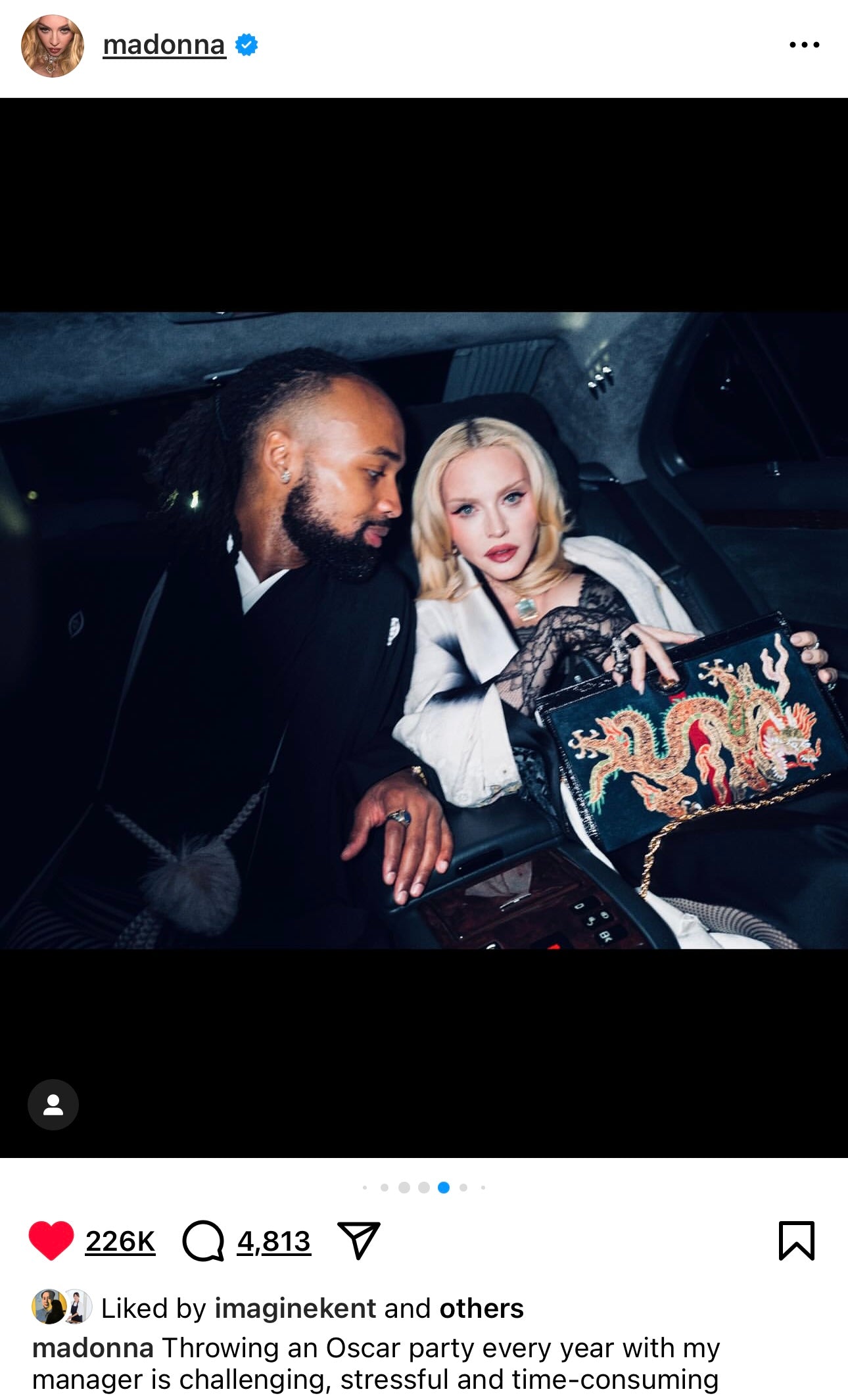 Madonna sitting in a car wearing a KIMONO SK outfit and holding a Gucci bag with a dragon embroidery.