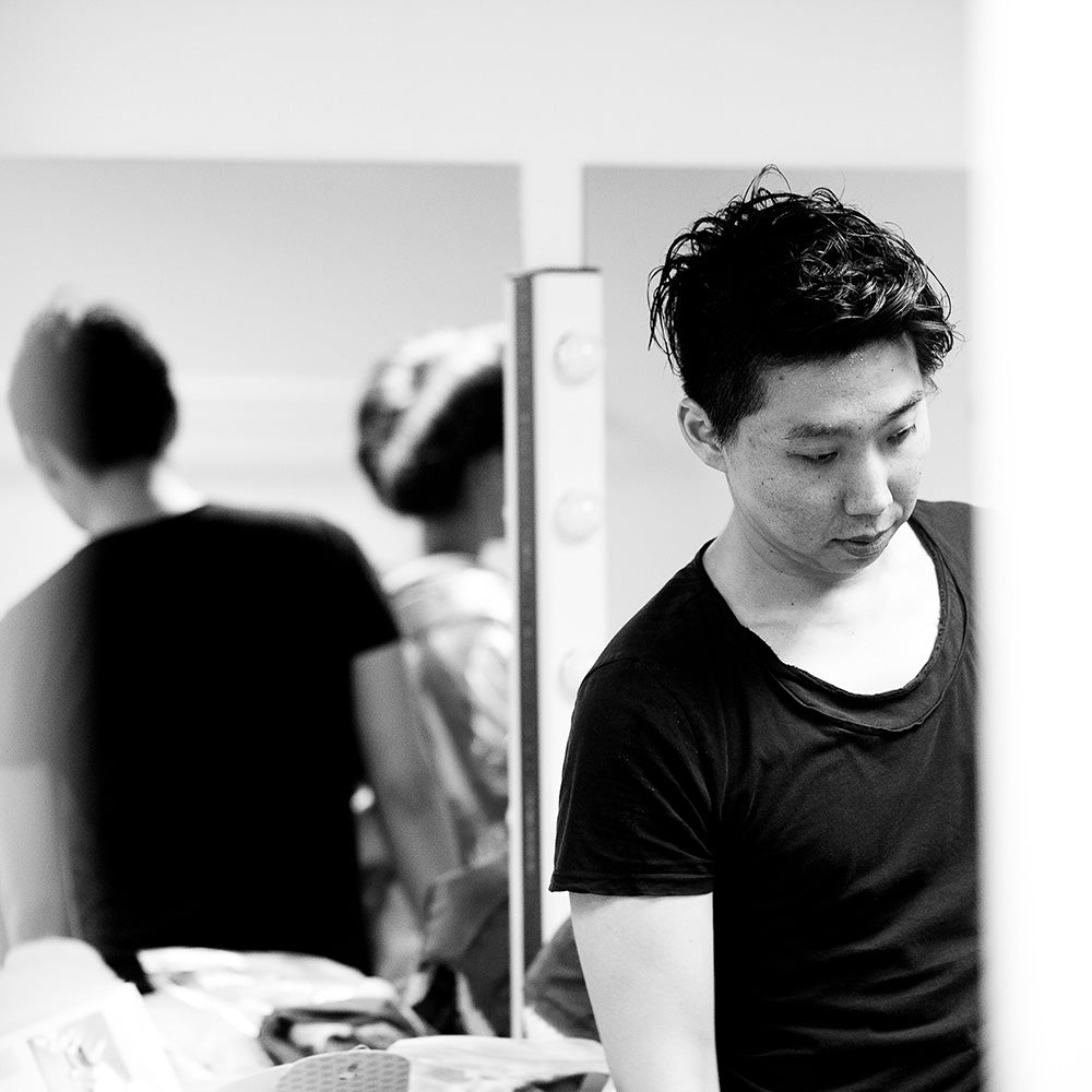 Kentaro Terauchi wearing a black t-shirt in a blurred indoor setting