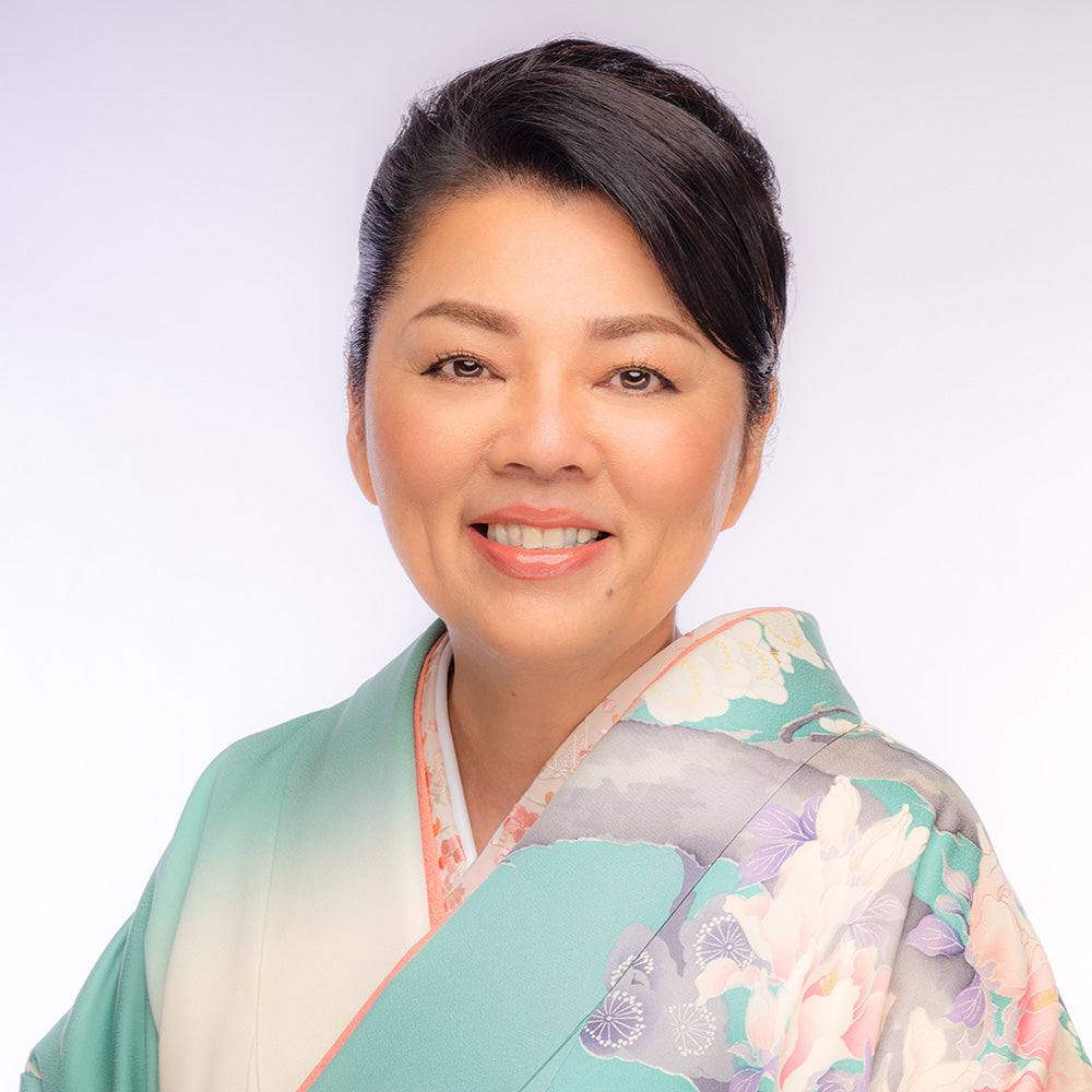 Sueko Oshimoto wearing a colorful kimono against a white background